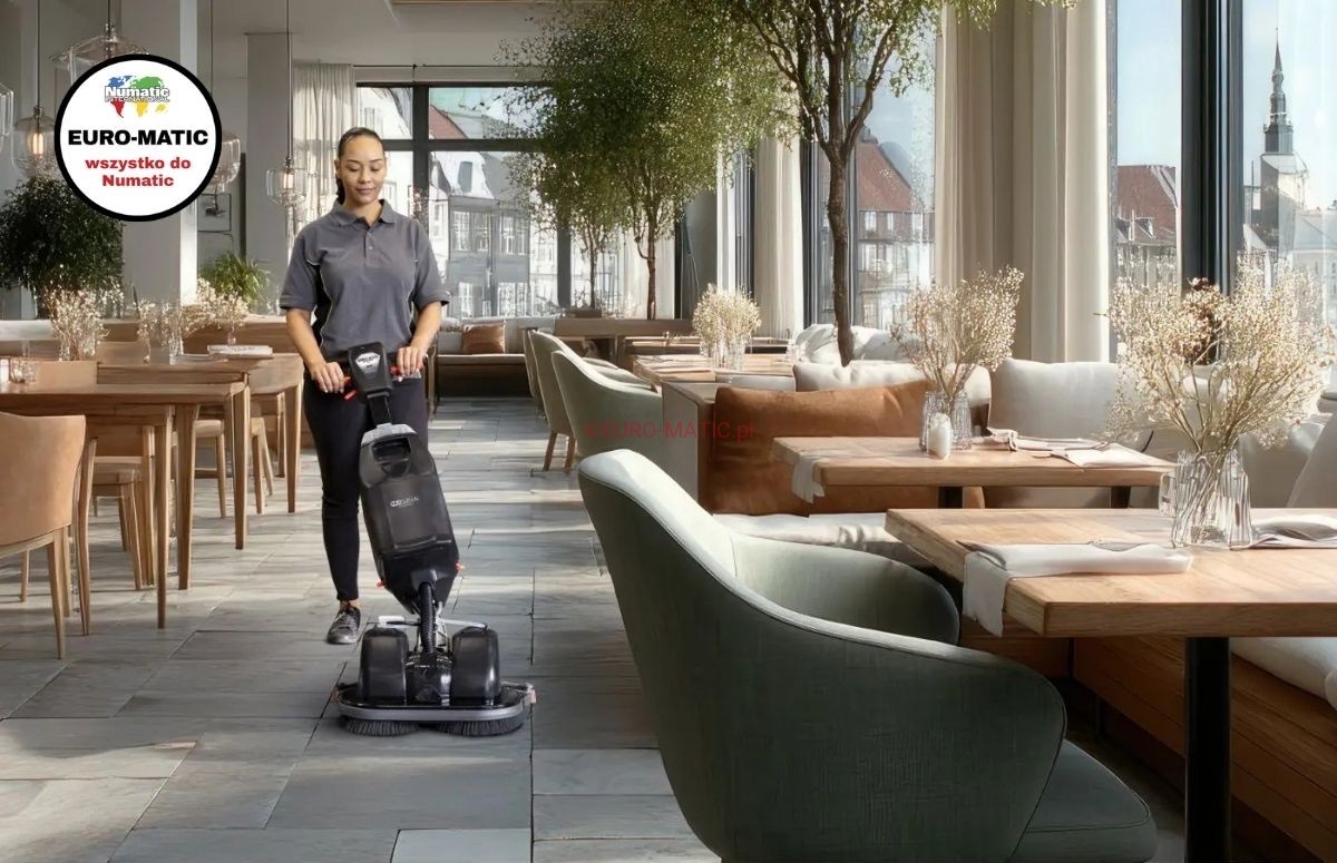 Maszyna Numatic NCC440NX podczas mycia podłogi w sali restauracyjnej między stolikami